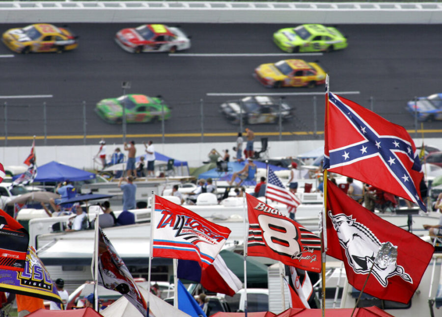 A Confederate flag flies in the infield as cars come out of Turn 1 during a NASCAR auto race at Talladega Superspeedway in Alabama