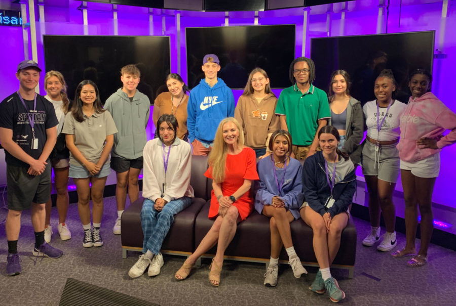 NBC 5 reporter and TCU alumna Noelle Walker poses with campers and counselors in the student media newsroom after her talk on Tuesday, June 21, 2022. From left, back row: counselors Charles Baggerly and Katherine Vaughn, campers Emma Rikalo, Jacob Pasteur, Makayla Lopez, James Chandler, Jessica Ward, Kenneth Turnipseed, Claire Spillman, Kennedi Harris and Fancy Ford. Seated: Callie Ehlmann, Noelle Walker, Kamryn Enrriquez and Harper Harris.